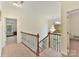 Upstairs hallway with chandelier and wrought iron railing at 8839 Blooming Arbor St, Huntersville, NC 28078