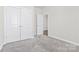 Bedroom featuring neutral carpet, double door closet, and an entry to an adjoining room at 9307 Dufaux Dr, Charlotte, NC 28278