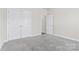 Cozy bedroom with neutral carpet, a double door closet, and white trim for a clean, modern look at 9307 Dufaux Dr, Charlotte, NC 28278