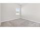 Neutral bedroom featuring carpet, white trim, and a window providing natural light at 9307 Dufaux Dr, Charlotte, NC 28278