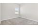 Simple bedroom with grey carpet and window at 9307 Dufaux Dr, Charlotte, NC 28278