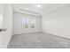 Bright bedroom with gray carpeting and two windows at 9307 Dufaux Dr, Charlotte, NC 28278