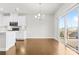 Open-concept dining area with wood flooring, modern chandelier, and sliding glass doors to the outdoor deck at 9307 Dufaux Dr, Charlotte, NC 28278