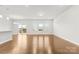 Bright and airy living room with wood flooring and ample natural light from large windows and glass door at 9307 Dufaux Dr, Charlotte, NC 28278