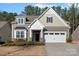 Two-story house with neutral siding, white garage door, and landscaping at 116 Van Gogh Trl, Mount Holly, NC 28120