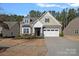 Two-story house with neutral siding, white garage door, and landscaping at 116 Van Gogh Trl, Mount Holly, NC 28120