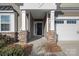 Front entrance with stone accents, columns, and a black door at 116 Van Gogh Trl, Mount Holly, NC 28120