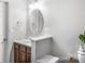 Bathroom with dark brown vanity, an oval mirror, and a sink at 13010 Marlstone Ln, Charlotte, NC 28215