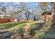 Back of house with stone pathway and mature trees at 1334 Woodland Dr, Charlotte, NC 28205