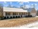 Tan house with white porch and landscaping; snowy lawn at 1417 Wildwood Dr, Kannapolis, NC 28081