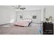 Well-lit carpeted bedroom featuring a ceiling fan and two windows at 146 Dogwood Grove Pl, Troutman, NC 28166