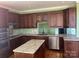 Kitchen with dark wood cabinets, granite island, and stainless steel appliances at 250 Bost Rd, China Grove, NC 28023