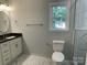 Updated bathroom featuring marble floors, vanity with gold fixtures, and a window bringing in natural light at 305 General As Johnston St, Stanley, NC 28164