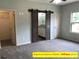 Bright bedroom featuring a barn door to the bathroom and grey carpet at 305 General As Johnston St, Stanley, NC 28164