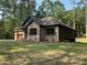 Angle of new construction home with low profile roof and tidy front lawn with mature trees and fresh sod at 305 General As Johnston St, Stanley, NC 28164