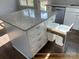 White kitchen island with granite countertop and built-in trash bins at 305 General As Johnston St, Stanley, NC 28164