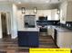 Spacious kitchen with granite island and dark blue cabinets at 305 General As Johnston St, Stanley, NC 28164