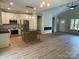 Bright open floor plan combining a modern kitchen with an island, fireplace, and a dining area with plenty of natural light at 305 General As Johnston St, Stanley, NC 28164