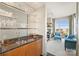 Wet bar with granite countertop, sink, and glass shelving at 333 W Trade St # 1204, Charlotte, NC 28202