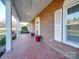 Brick front porch with red pots and tiled flooring at 44101 Millingport Rd, Richfield, NC 28137