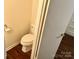 Small half bathroom with toilet and wood floor at 4618 Old Lantern Way, Charlotte, NC 28212