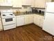 White kitchen with wood flooring and appliances at 4618 Old Lantern Way, Charlotte, NC 28212