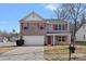 Two-story brick home with a white garage door and red accents at 709 Ferrell Ave, Charlotte, NC 28216