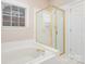 Bathroom with a bathtub and a shower with gold accents at 9729 Cockerham Ln, Huntersville, NC 28078