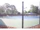 Well-maintained tennis court with chain-link fence and covered seating at 9729 Cockerham Ln, Huntersville, NC 28078