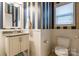 Small bathroom with navy and white striped walls, white vanity, and toilet at 1147 Wagner Ave, Fort Mill, SC 29715