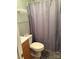 Bathroom featuring a toilet, sink, wood cabinet, and a shower with a patterned gray curtain at 212 W Bingham St, Statesville, NC 28677