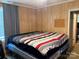Cozy bedroom featuring wood walls, and a comfortable bed with striped linens and a gray curtain at 212 W Bingham St, Statesville, NC 28677
