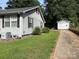 Exterior view of the side of the house and garage featuring manicured lawn and paved driveway at 212 W Bingham St, Statesville, NC 28677