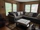 Comfortable living room with a large sectional sofa, accent pillows, and a button-tufted ottoman at 212 W Bingham St, Statesville, NC 28677