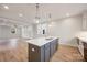 A modern kitchen with gray cabinets, marble countertops, pendant lighting, and an open concept design at 225 Davidson Gateway Dr, Davidson, NC 28036