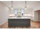 A modern kitchen with white cabinets, marble countertops, and pendant lighting for an elegant aesthetic at 225 Davidson Gateway Dr, Davidson, NC 28036
