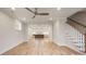 Bright living room featuring hardwood floors, staircase, and seamless transition into a modern kitchen at 225 Davidson Gateway Dr, Davidson, NC 28036