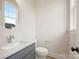 Powder room with round mirror and modern fixtures at 225 Davidson Gateway Dr, Davidson, NC 28036