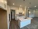 Modern kitchen with white cabinets, a central island, stainless steel appliances, and hardwood floors at 3103 Beacon Heights Rd, Indian Land, SC 29707