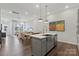 Spacious kitchen with hardwood flooring, kitchen island, modern pendant lighting and stainless steel appliances at 3107 Beacon Heights Rd, Indian Land, SC 29707