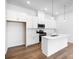 Modern kitchen with white cabinets, stainless steel appliances, an island, and hardwood floors at 3109 Beacon Heights Rd, Indian Land, SC 29707