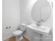 Half-bathroom featuring a modern sink and a large, round mirror, plus neutral finishes at 3111 Beacon Heights Rd, Indian Land, SC 29707