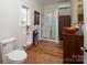 Modern bathroom with a walk-in shower, urinal, and stylish wood-look flooring at 42610 Moonshine Dr, New London, NC 28127