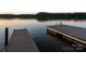 Two lakeside docks with serene water and forest views, perfect for relaxation and recreation at 42610 Moonshine Dr, New London, NC 28127