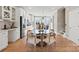 Kitchen and dining area with glass table, white cabinets, and hardwood floors at 5033 Westmead Ln, Charlotte, NC 28262