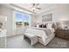 Spacious bedroom with large windows, tray ceiling, ceiling fan, and plush neutral-toned furnishings at 5037 Westmead Ln, Charlotte, NC 28262