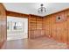 Dining room with wood paneling, built-in shelving, and hardwood floors. View of sunroom at 550 Woodleaf Barber Rd, Cleveland, NC 27013