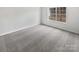 Simple bedroom with gray carpeting and a large window at 6041 Pinebark Ct, Charlotte, NC 28212