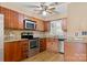 Well-lit kitchen featuring stainless steel appliances, wood cabinets, granite countertops, and tile backsplash at 9801 Emerald Point Dr # 2, Charlotte, NC 28278