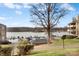 Scenic view of a lake with boats docked, surrounded by trees, and a building with a tree at 9801 Emerald Point Dr # 2, Charlotte, NC 28278